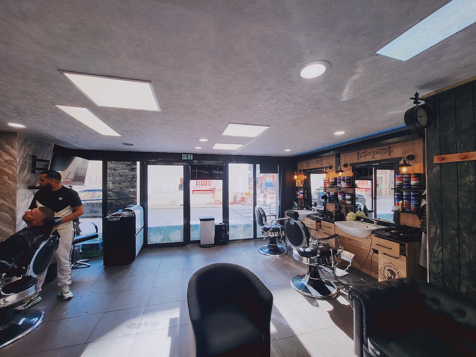 Intérieur du salon H&S Barber Shop Thonon-les-Bains — fauteuils et postes de coiffure